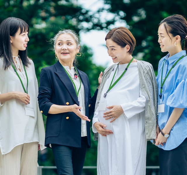 笑顔で妊婦を囲む女性達