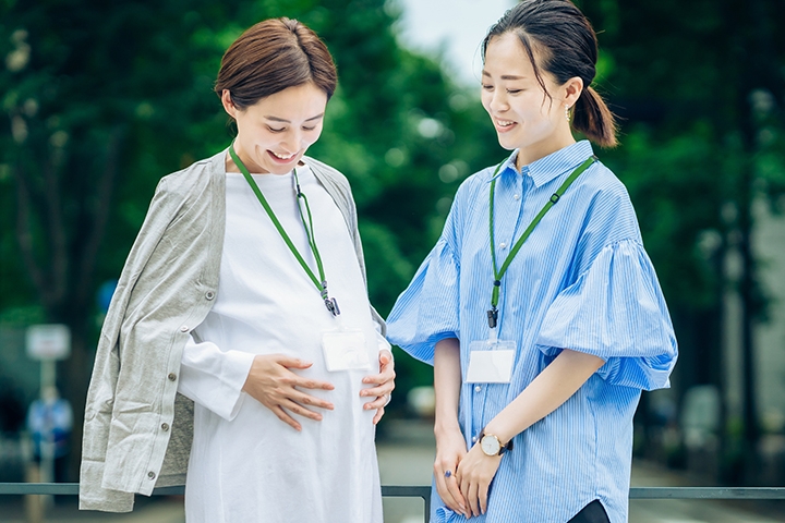 妊婦の女性と妊婦のお腹をみる女性